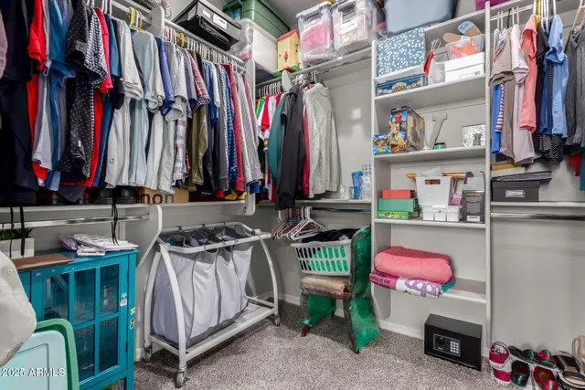 a view of walk in closet with clothes and shoes
