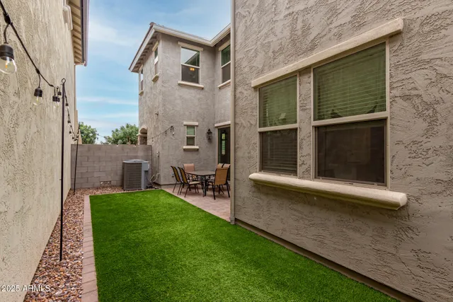 a view of a chair and table in backyard of the house