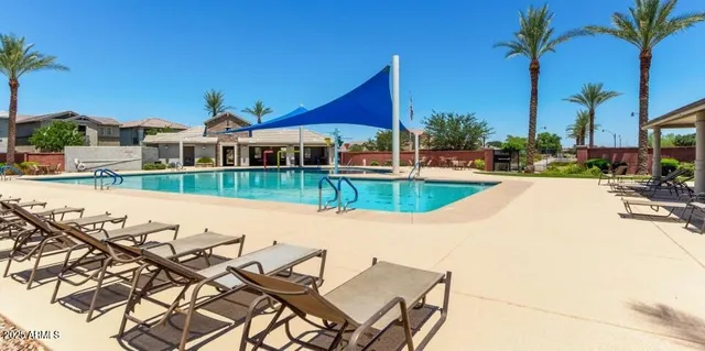 a view of a house with pool and chairs