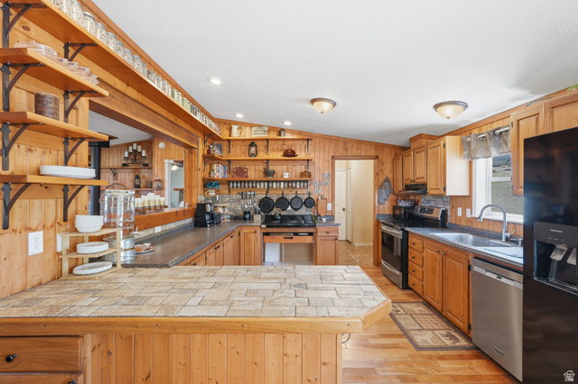 8066 North Valley View Heights Preston, ID 83263 - Photo 12 of 34 Spacious kitchen featuring extensive wood-finish cabinetry, a tiled island countertop, stainless steel appliances, and recessed lighting