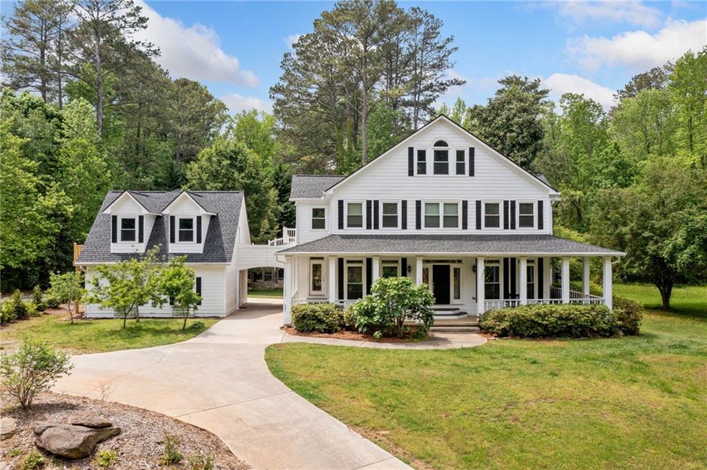 a front view of a house with a yard and potted plants
