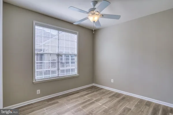 a view of an empty room with a window and a ceiling fan