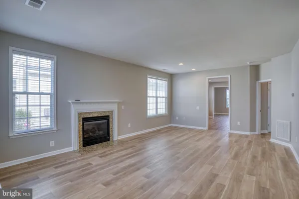 an empty room with windows and a fireplace