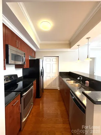 a kitchen with stainless steel appliances granite countertop a stove a sink and a refrigerator