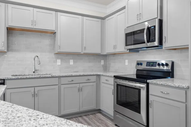 a kitchen with cabinets stainless steel appliances and a sink