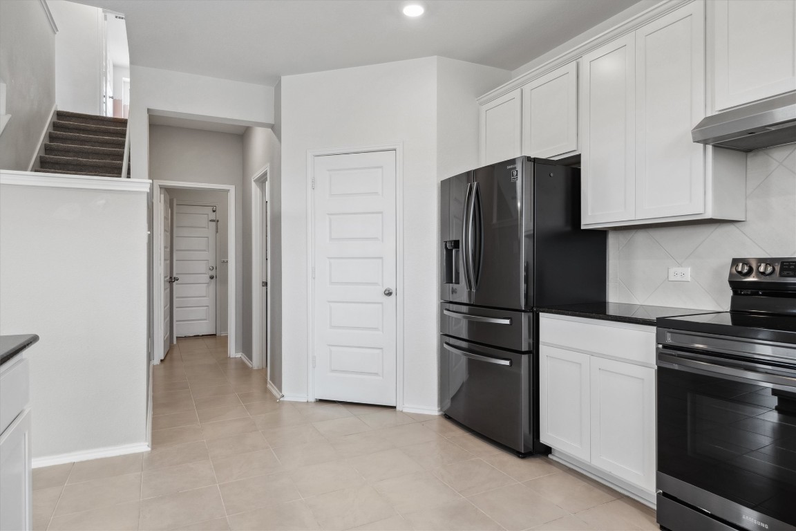 925 Yellow Ribbon Trail Jarrell, TX 76537 - Photo 12 of 35 a kitchen with a refrigerator and cabinets