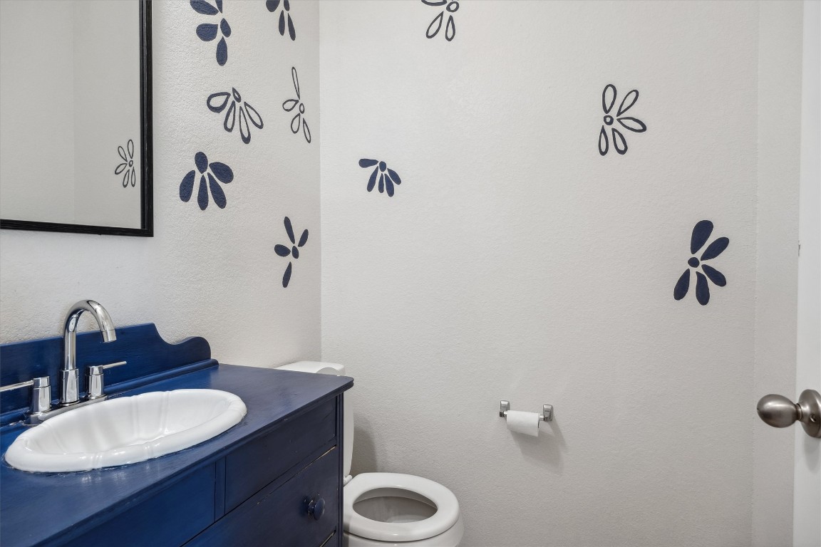 925 Yellow Ribbon Trail Jarrell, TX 76537 - Photo 13 of 35 a bathroom with a granite countertop sink a mirror and a toilet