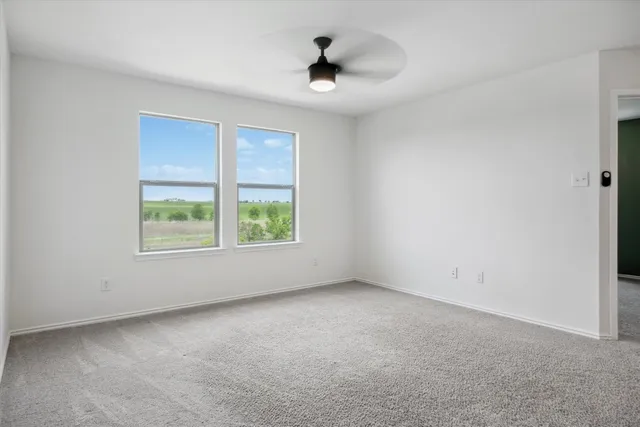 an empty room with a ceiling fan and mirror