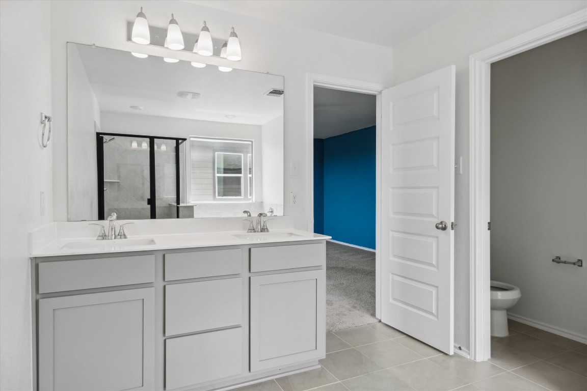 925 Yellow Ribbon Trail Jarrell, TX 76537 - Photo 29 of 35 a bathroom with a double vanity sink mirror and toilet