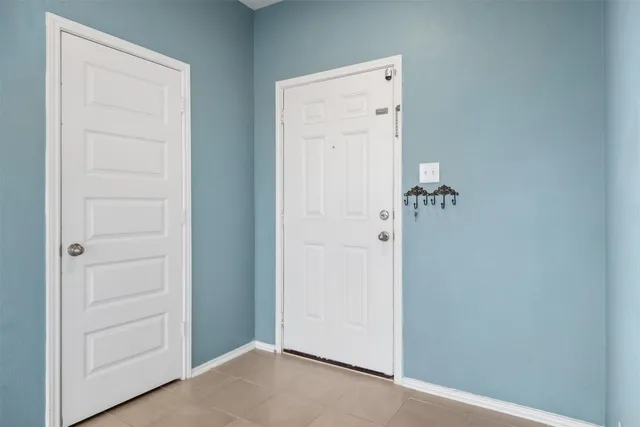 an empty room with chandelier and windows