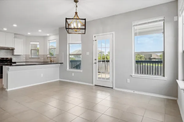 an empty room with windows and ceiling fan