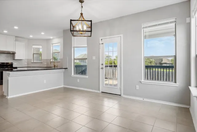 an empty room with windows and ceiling fan