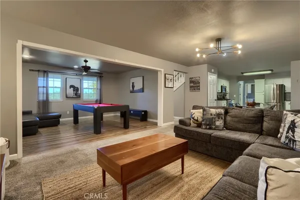 a living room with furniture a rug and a chandelier