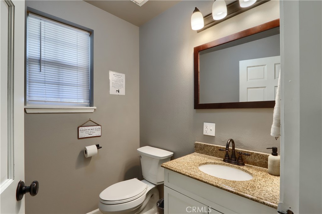 5197 Colorado Road Midpines, CA 95345 - Photo 25 of 47 a bathroom with a granite countertop toilet sink and mirror