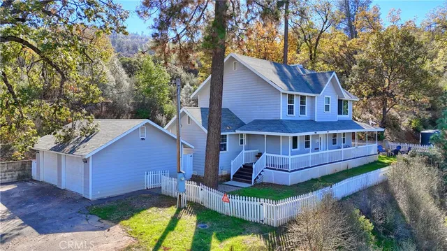a view of a big house with wooden fence next to a road