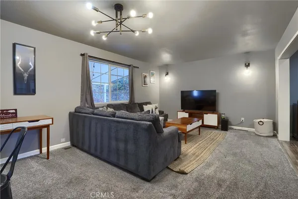 a living room with furniture a flat screen tv and a window