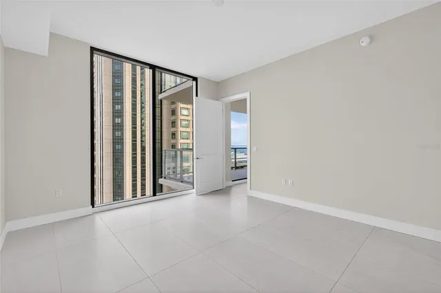 a view of a kitchen with refrigerator and white cabinets