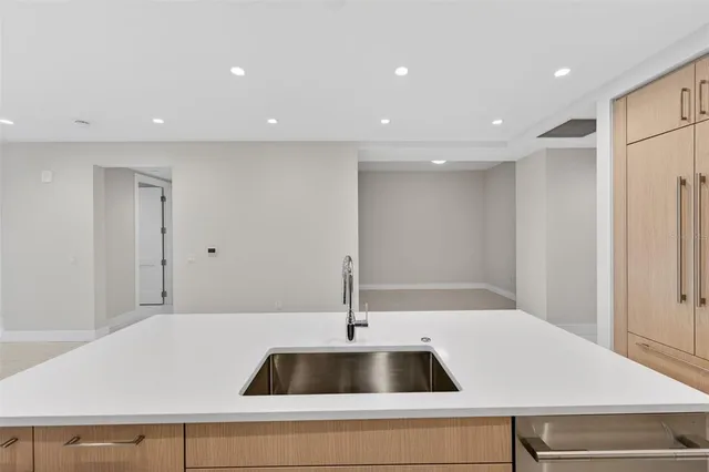 a living room with furniture potted plant and kitchen view