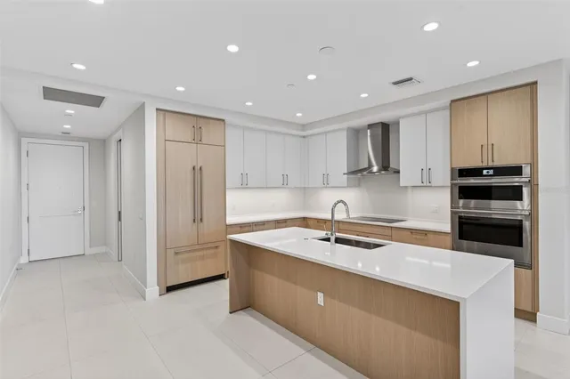 a kitchen with stainless steel appliances a sink a stove a refrigerator a microwave and cabinets