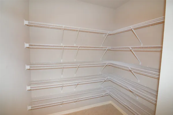 an empty room with wooden floor chandelier and fireplace