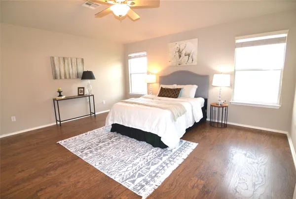 a bedroom with a bed and wooden floor