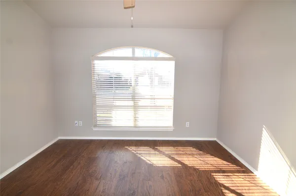 a view of an empty room with wooden floor
