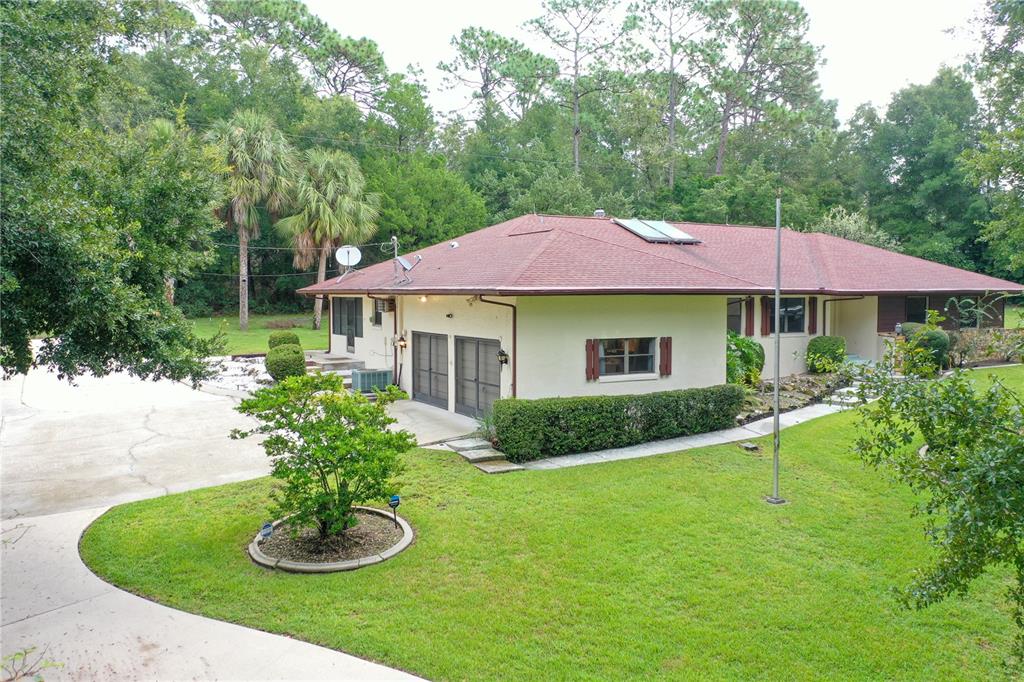 a view of a house with a yard and potted plants