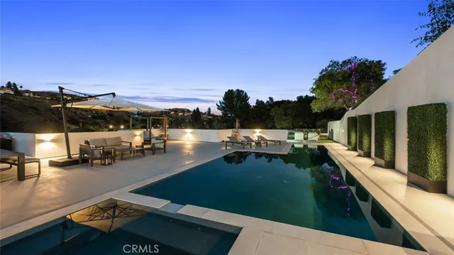 a large white kitchen with stainless steel appliances granite countertop a large stove a sink and a refrigerator