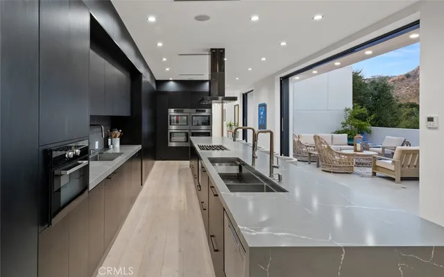 a kitchen with stainless steel appliances granite countertop a sink a stove and a refrigerator