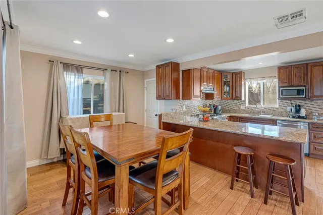 a kitchen with stainless steel appliances granite countertop a sink dishwasher stove refrigerator and cabinets