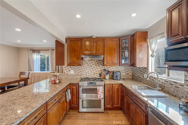 a kitchen with stainless steel appliances granite countertop a sink stove and refrigerator