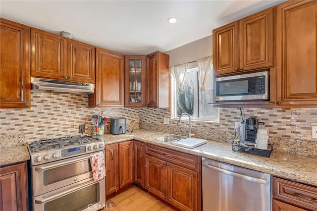 a kitchen with stainless steel appliances granite countertop a sink stove and microwave
