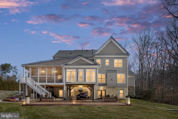 a view of a big house with a big yard and large trees