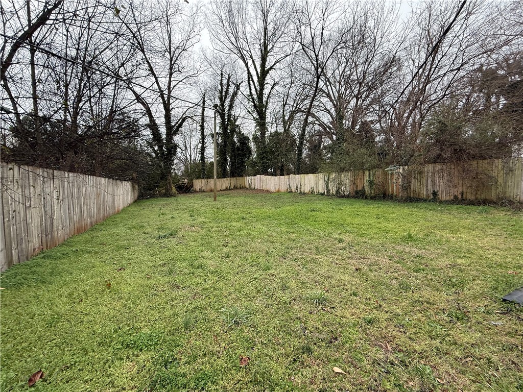 620 East Orr Street Anderson, SC 29621 - Photo 5 of 22 A spacious yard with mature trees and a sturdy wooden fence offers ample outdoor potential.