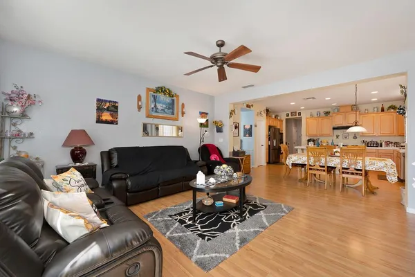 a view of a dining room and livingroom with furniture wooden floor a chandelier