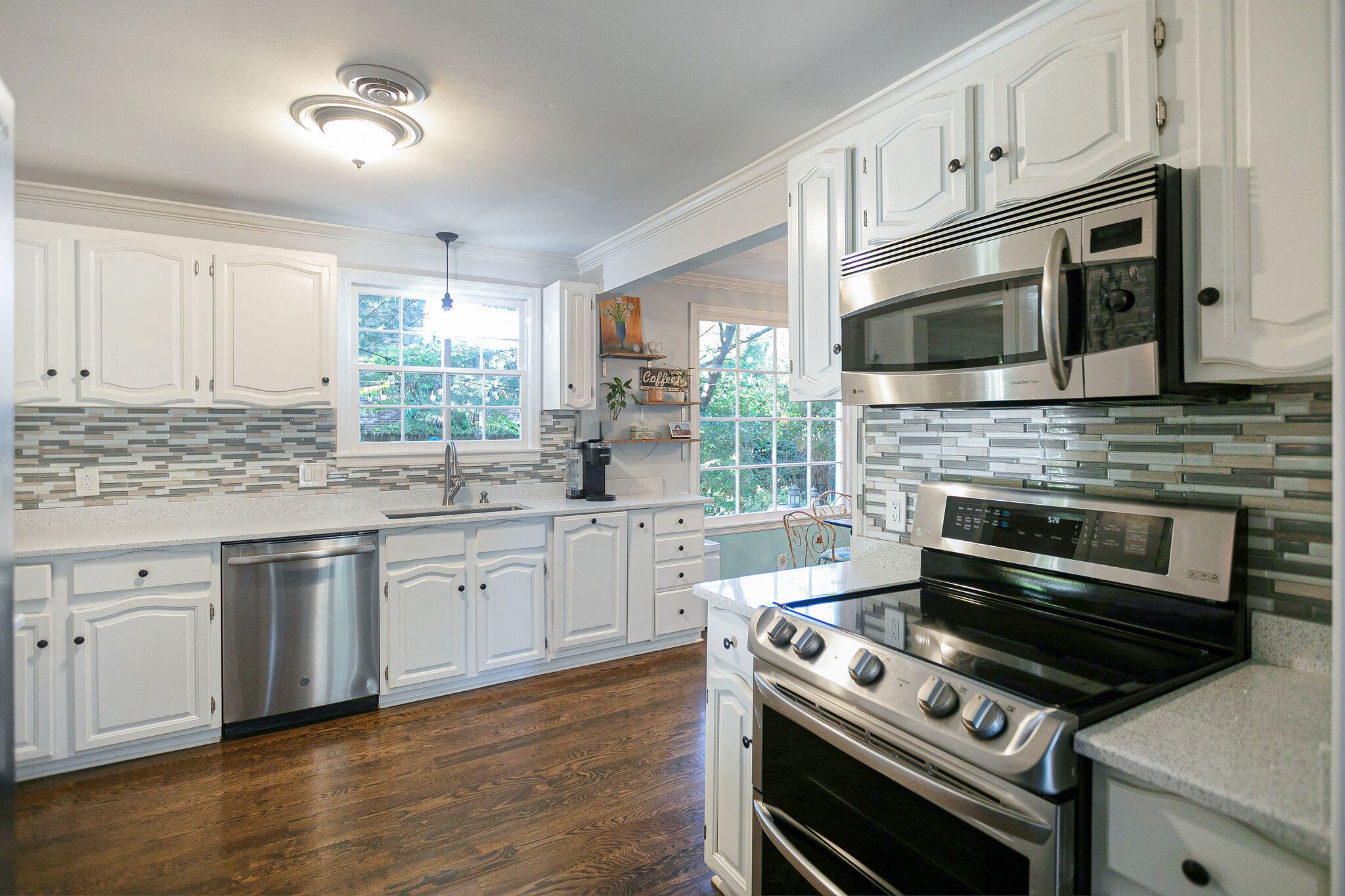 212 Gloucester Street Franklin, TN 37064 - Photo 10 of 23 a kitchen with stainless steel appliances white cabinets a stove a sink and a microwave