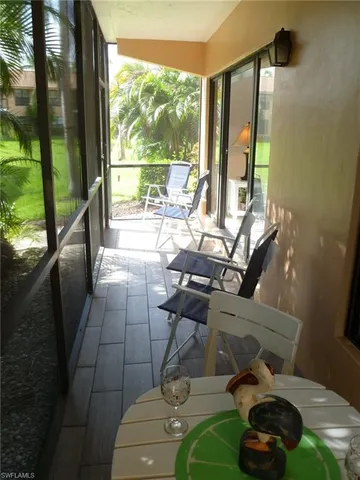 a living room with a floor to ceiling window and furniture