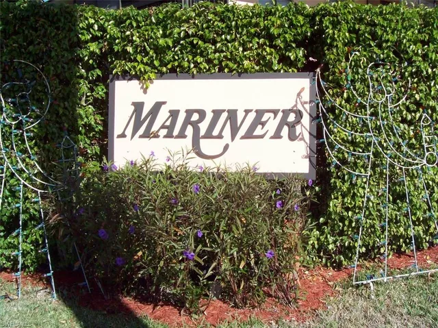 a sign that is sitting in front of a tree