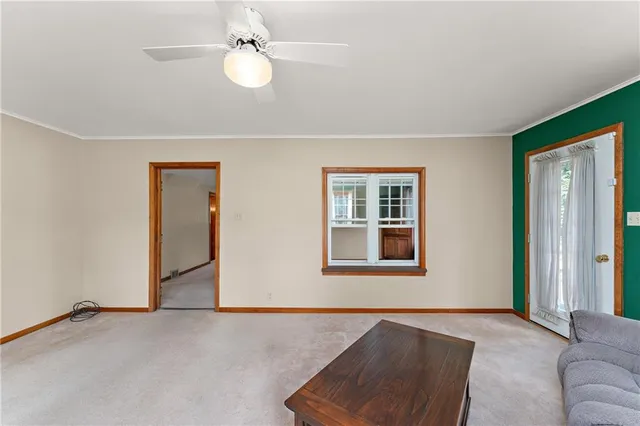 a livingroom with a ceiling fan and window