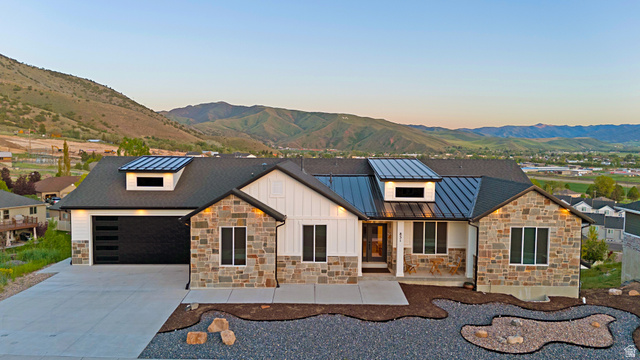 851 Grandview Drive Morgan, UT 84050 - Photo 53 of 68 Contemporary exterior featuring stone accents, white vertical siding, and a dark shingle roof with two prominent metal dormers
