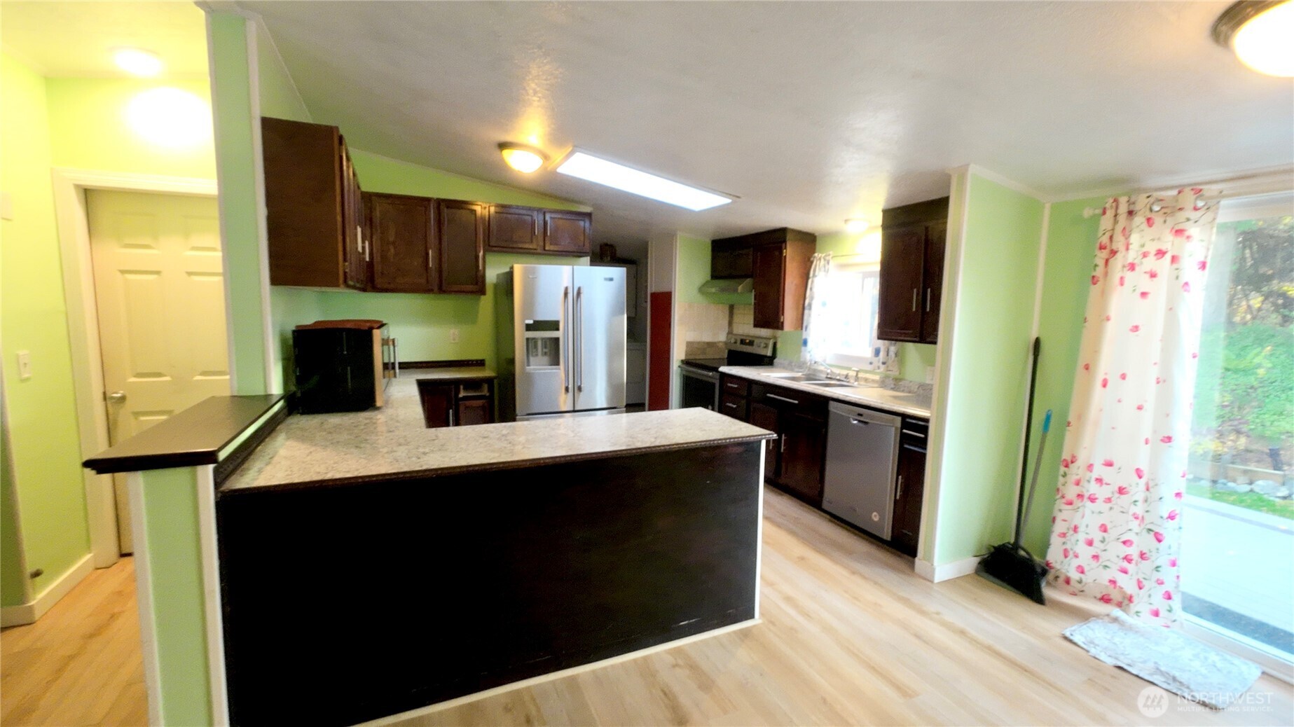 4672 Birch Bay Lynden Road, Unit 82 Blaine, WA 98230 - Photo 12 of 22 a kitchen with stainless steel appliances kitchen island granite countertop a refrigerator a sink dishwasher and a stove with wooden floor