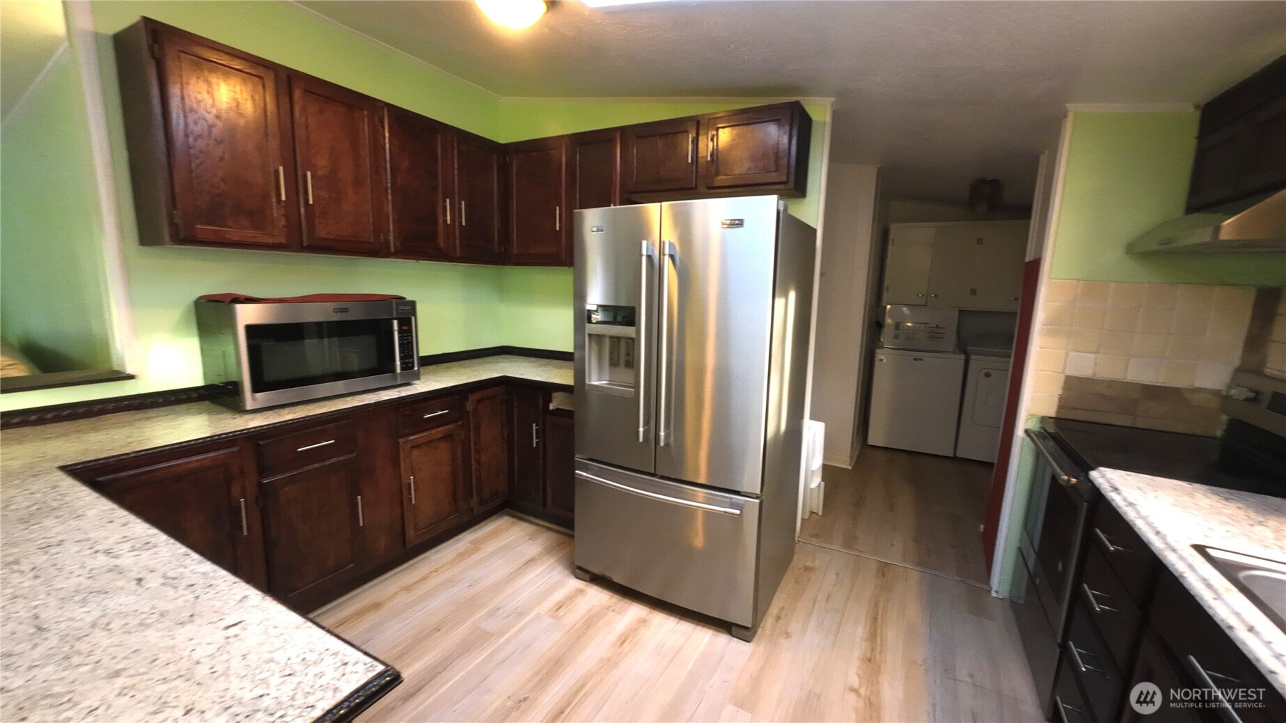 4672 Birch Bay Lynden Road, Unit 82 Blaine, WA 98230 - Photo 9 of 22 a kitchen with stainless steel appliances granite countertop a refrigerator microwave and wooden floor