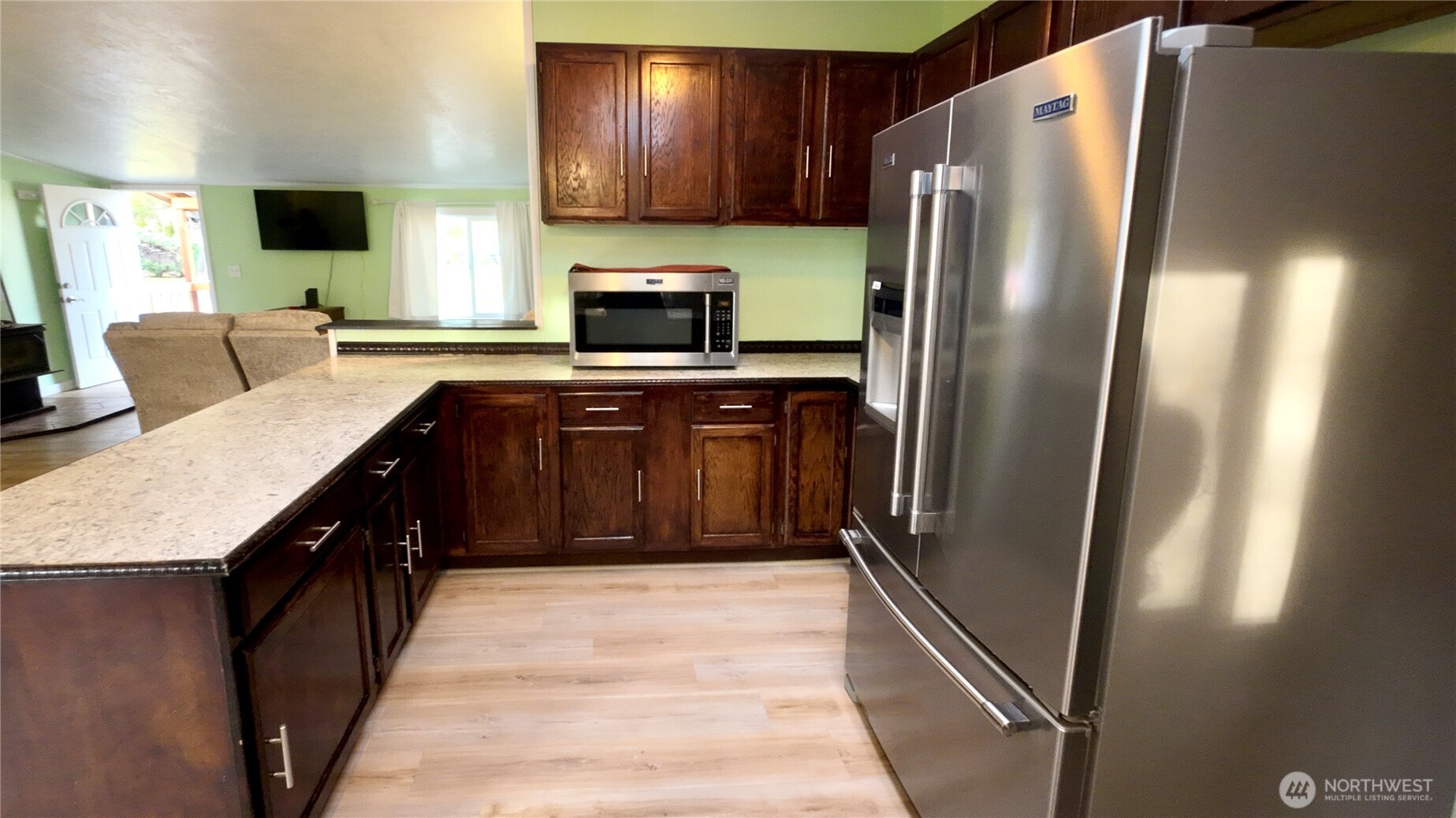 4672 Birch Bay Lynden Road, Unit 82 Blaine, WA 98230 - Photo 10 of 22 a kitchen with stainless steel appliances granite countertop a refrigerator a stove and a sink with wooden floor