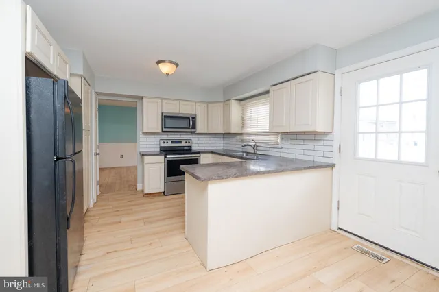 a kitchen with stainless steel appliances granite countertop a stove a sink and a refrigerator