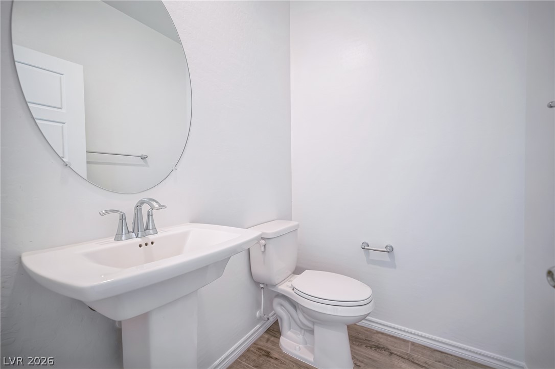 7348 North Decatur Boulevard, Unit 1 North Las Vegas, NV 89084 - Photo 6 of 17 A pristine powder room offers a sleek pedestal sink and contemporary wood-look flooring.