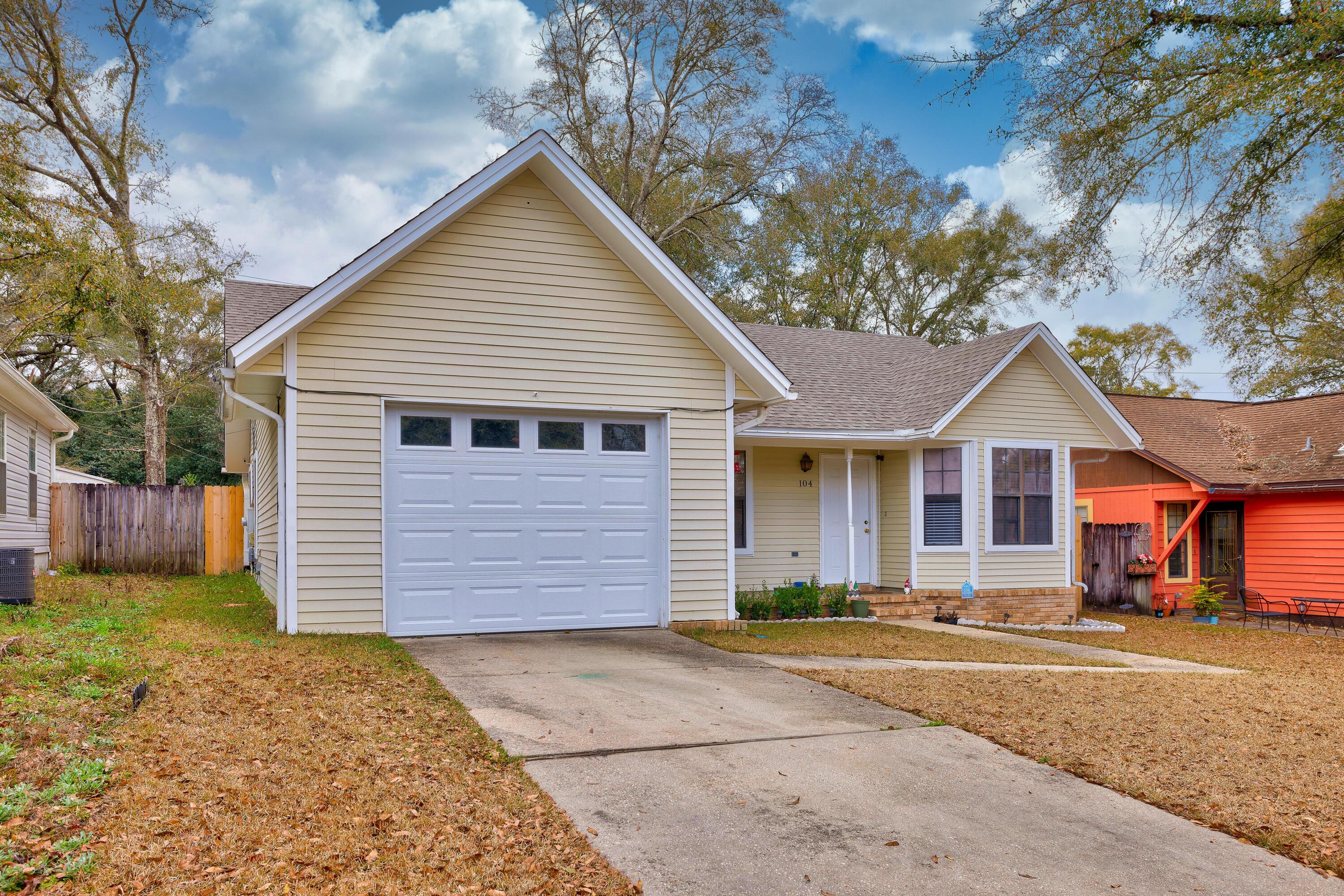 104 Fairoaks Drive Crestview, FL 32539 - Photo 2 of 24 a front view of a house with a yard and garage
