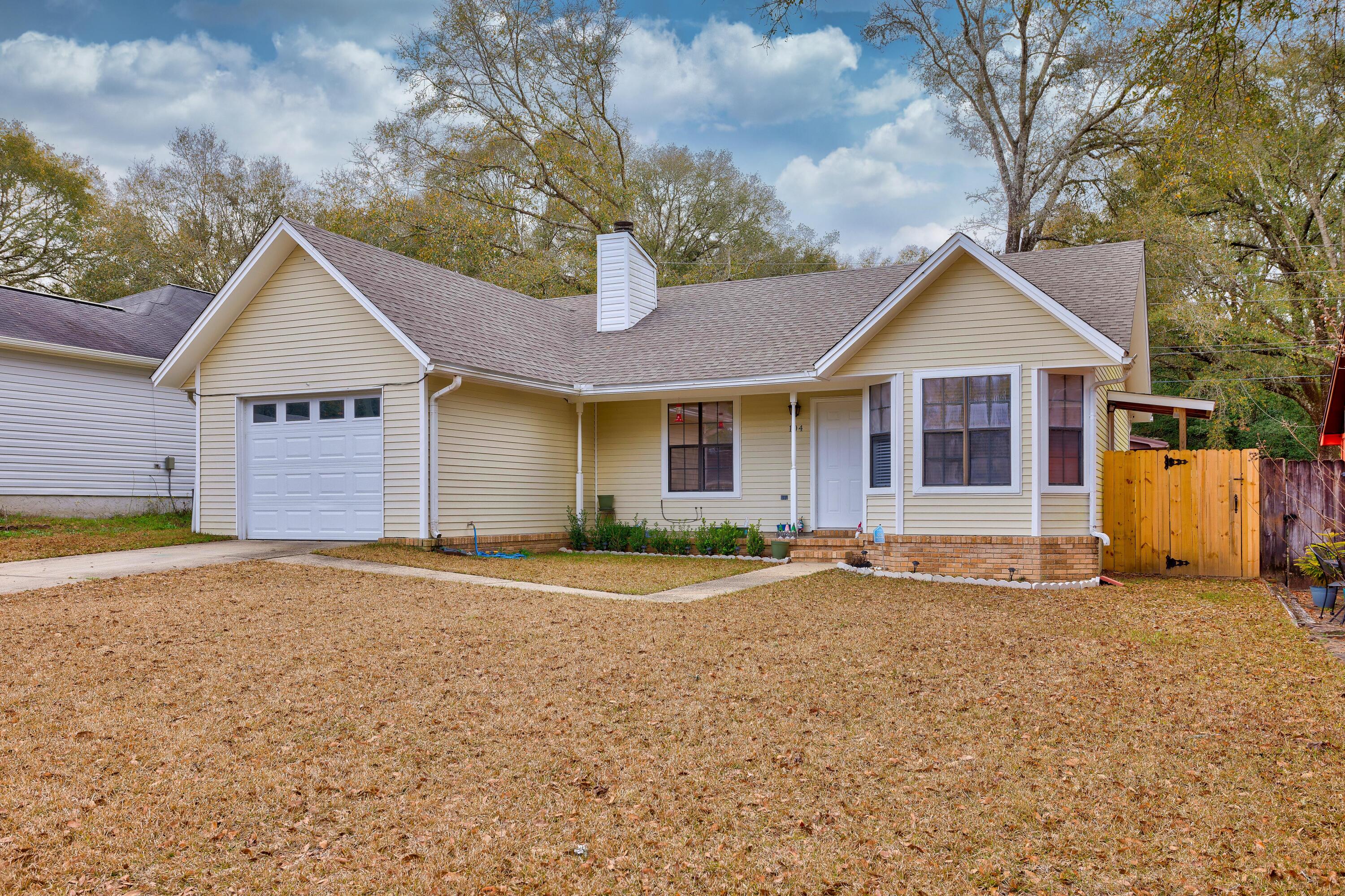 104 Fairoaks Drive Crestview, FL 32539 - Photo 3 of 24 a front view of a house with a garden and tree
