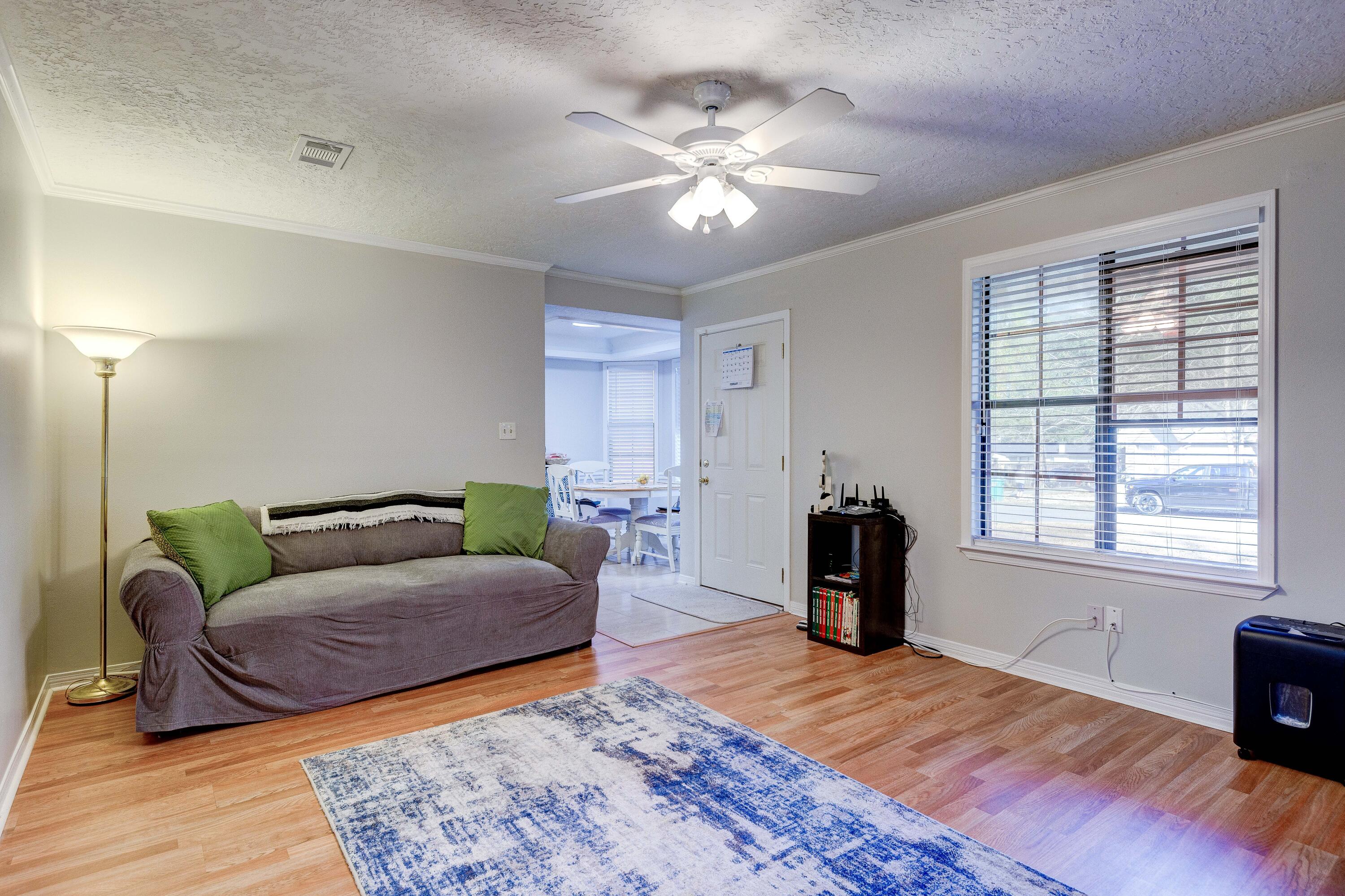 104 Fairoaks Drive Crestview, FL 32539 - Photo 6 of 24 a living room with furniture and a chandelier