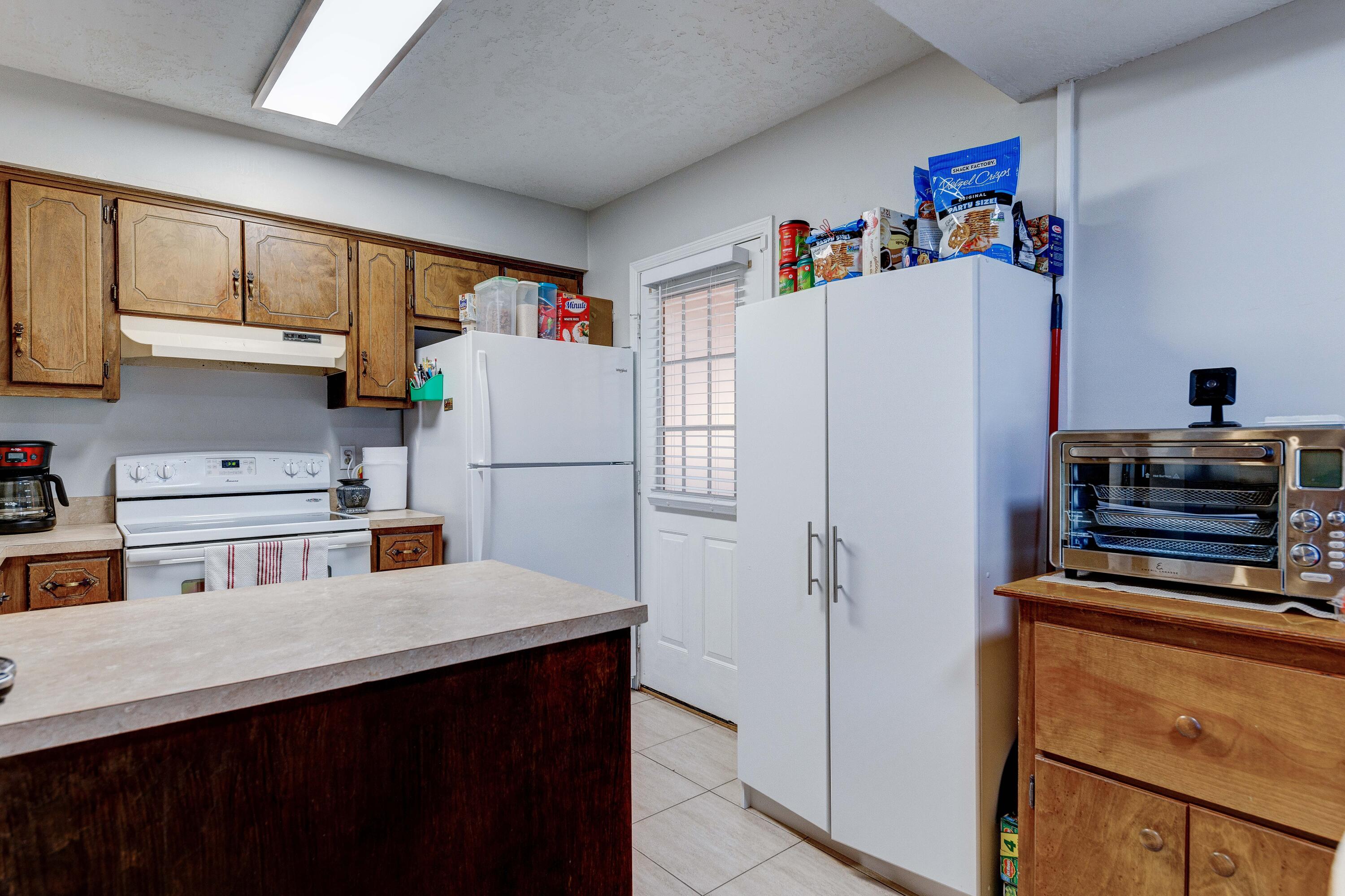 104 Fairoaks Drive Crestview, FL 32539 - Photo 9 of 24 a white kitchen with refrigerator a stove a sink and cabinets