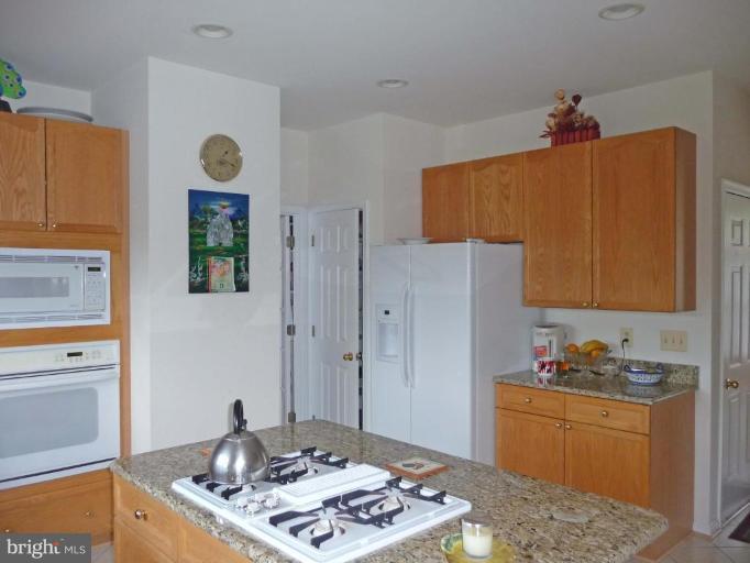 6089 Deer Ridge Trail Springfield, VA 22150 - Photo 11 of 30 a kitchen with stainless steel appliances granite countertop a refrigerator and a stove top oven